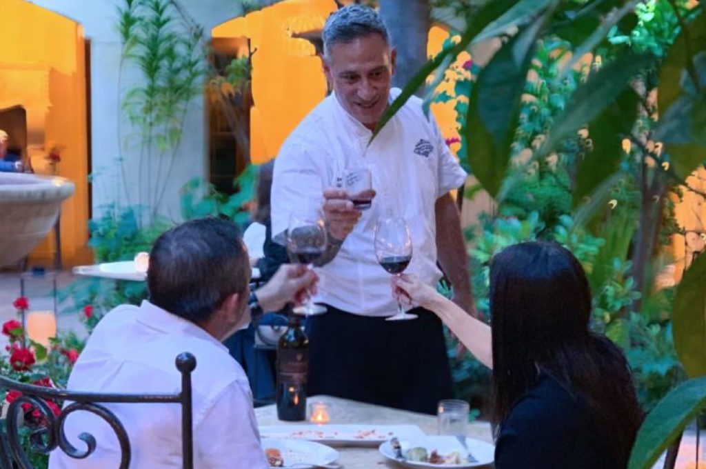 Chef Sam tossing a wine of glass with his clients